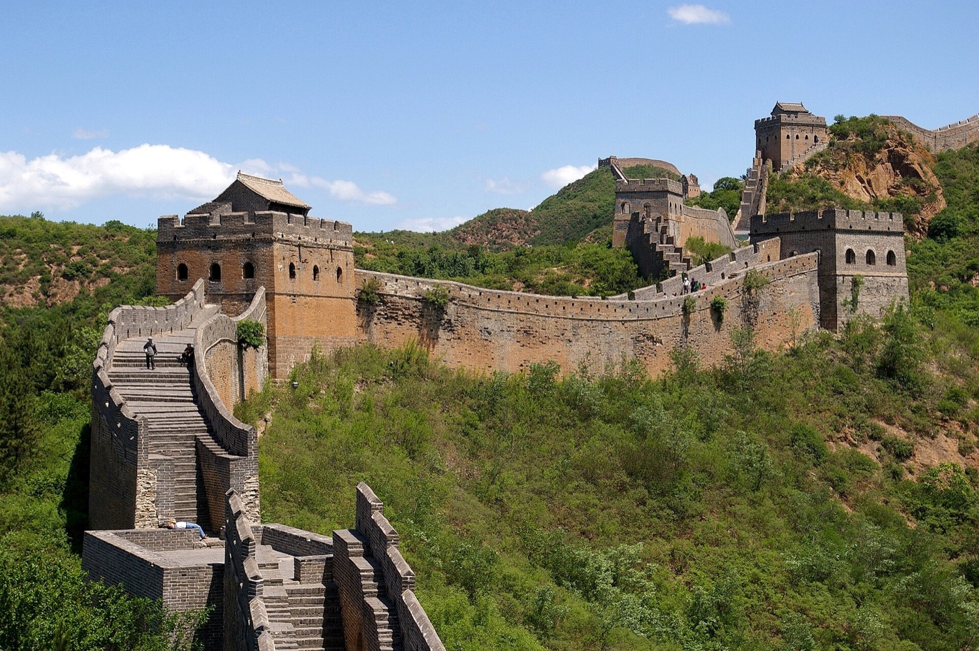 The Great Wall of China winding over green mountains